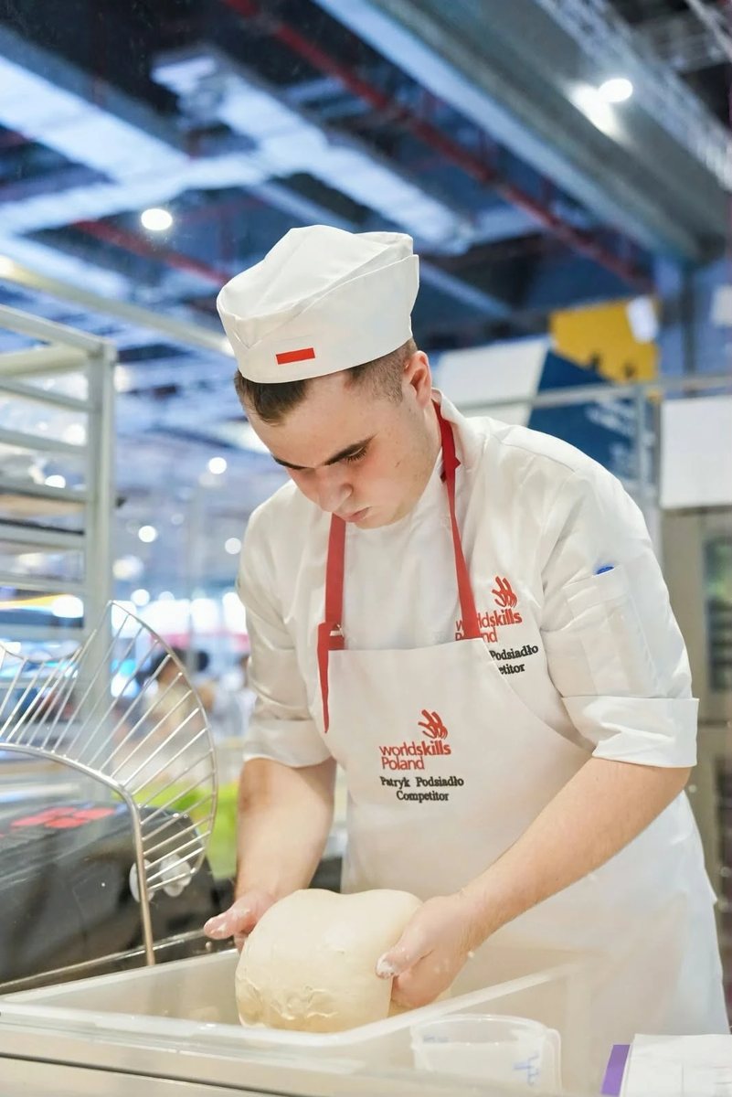 Patryk Podsiadło wyrabia ciasto podczas zadania konkursowego w konkurencji Piekarstwo na WorldSkills Shanghai 2026